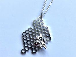 Photograph showing silver pendant of bee in hive. Winner of Schools Competition  