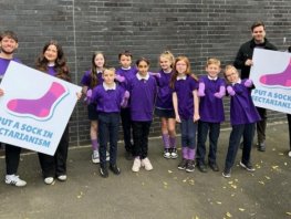 City students stand with Cairn Primary school children learning about their campaign (Image Nil by Mouth) 