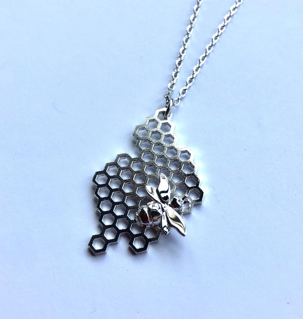 Photograph showing silver pendant of bee in hive_Mirin Scott winner of CoGC schools competition