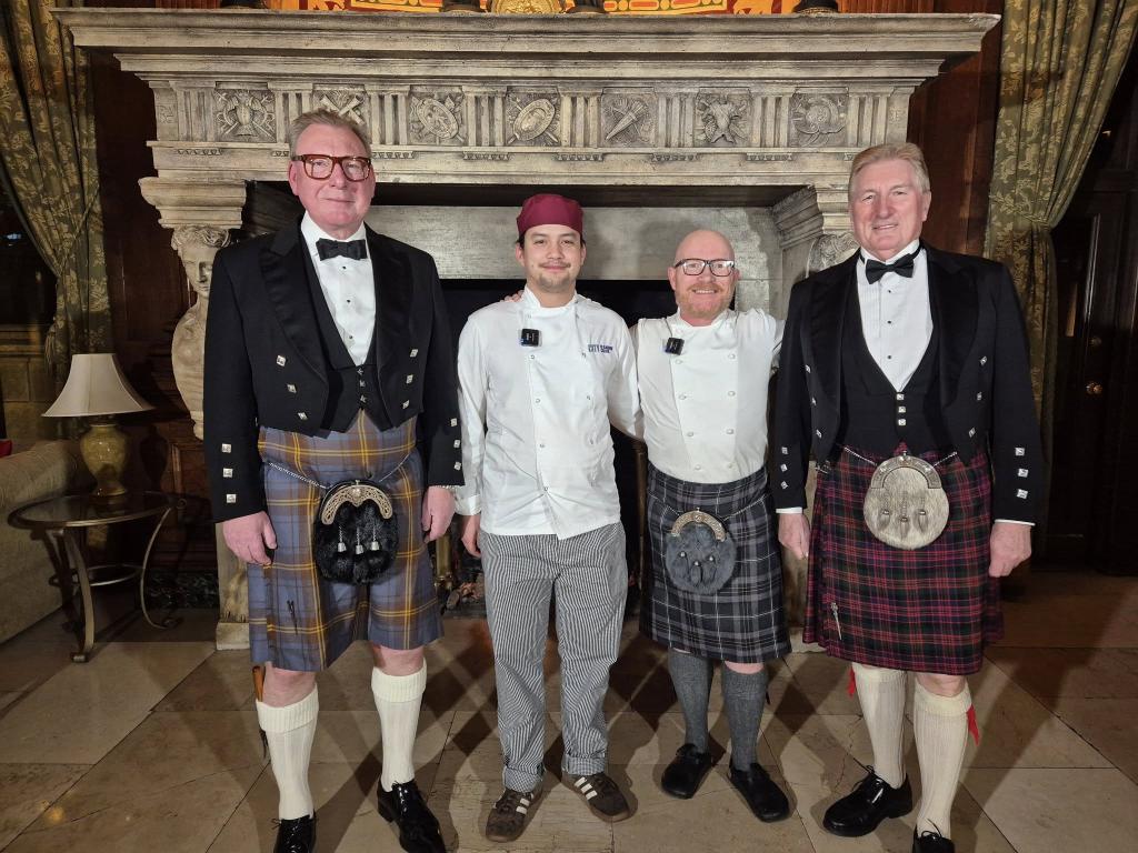 City student Charlton Russell poses with Gary MacLean and supper attendees