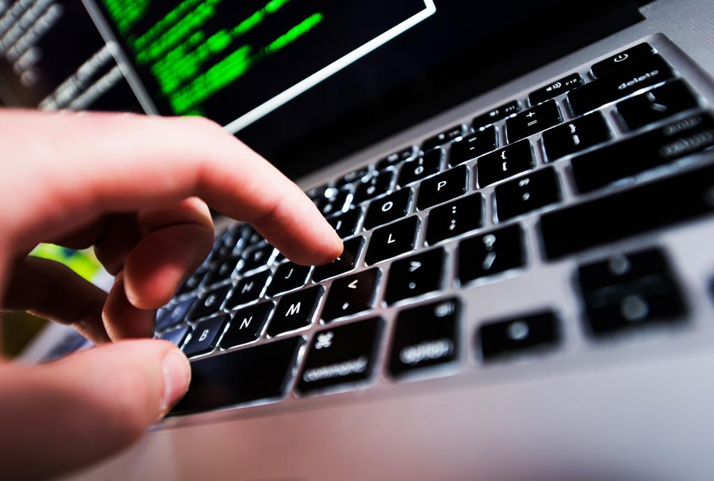 Close up image of laptop key with fingers typing.