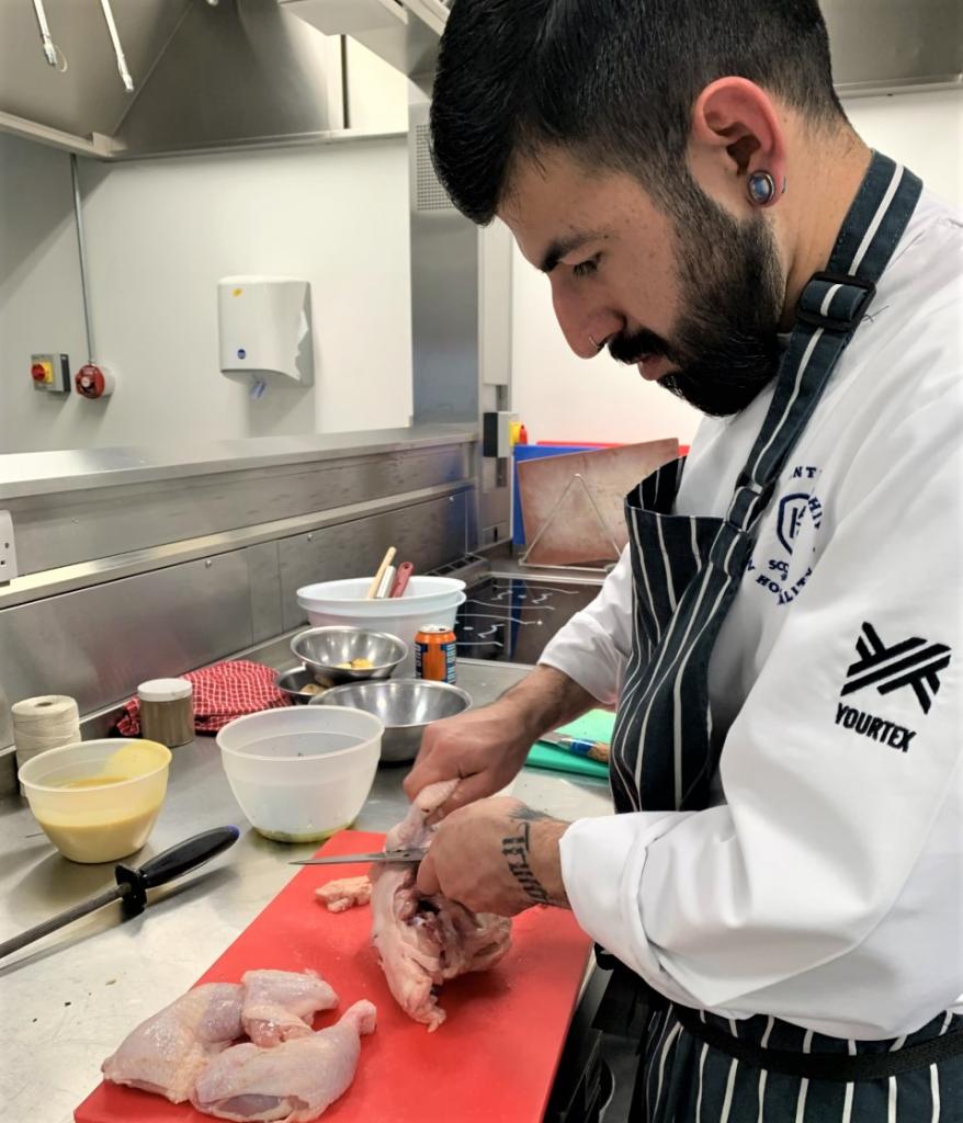 Photo of AHS cookery apprentice preparing in kitchen at City campus.