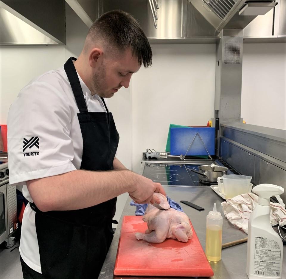 Photo of AHS cookery apprentice preparing in kitchen at City campus.