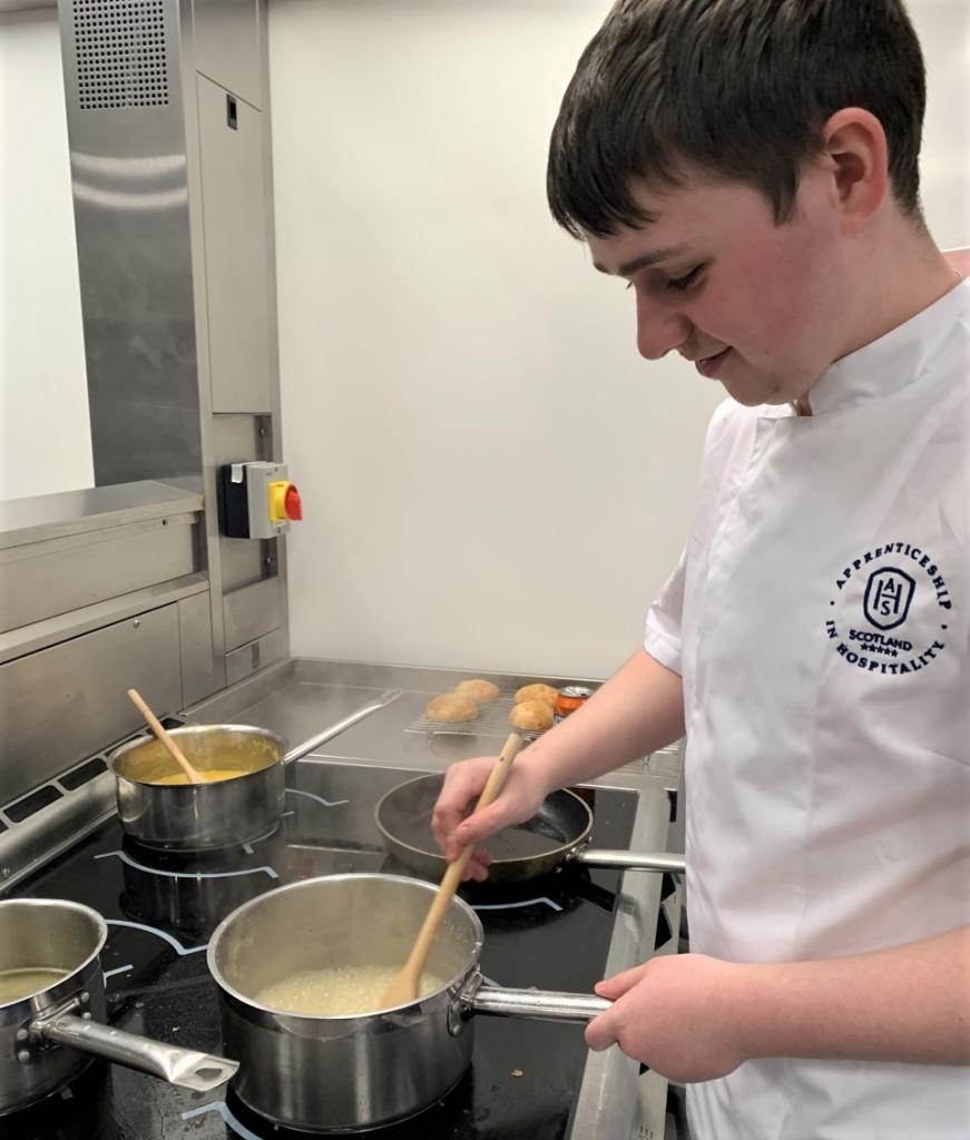 Photo of AHS cookery apprentice preparing in kitchen at City campus.