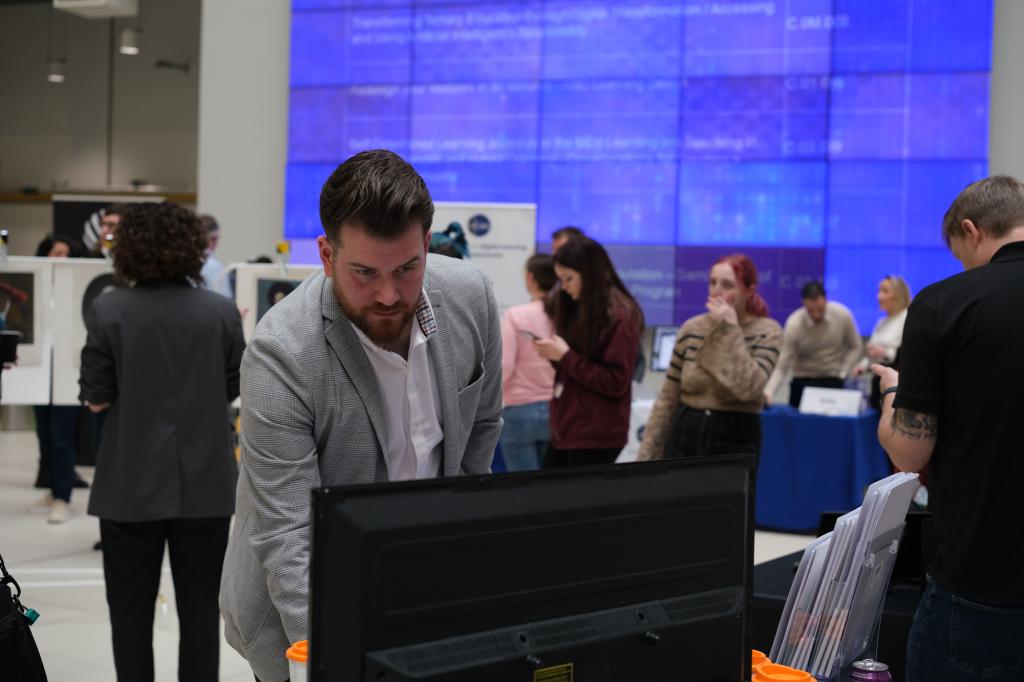 Staff in the atrium at City campus talking to exhibitors