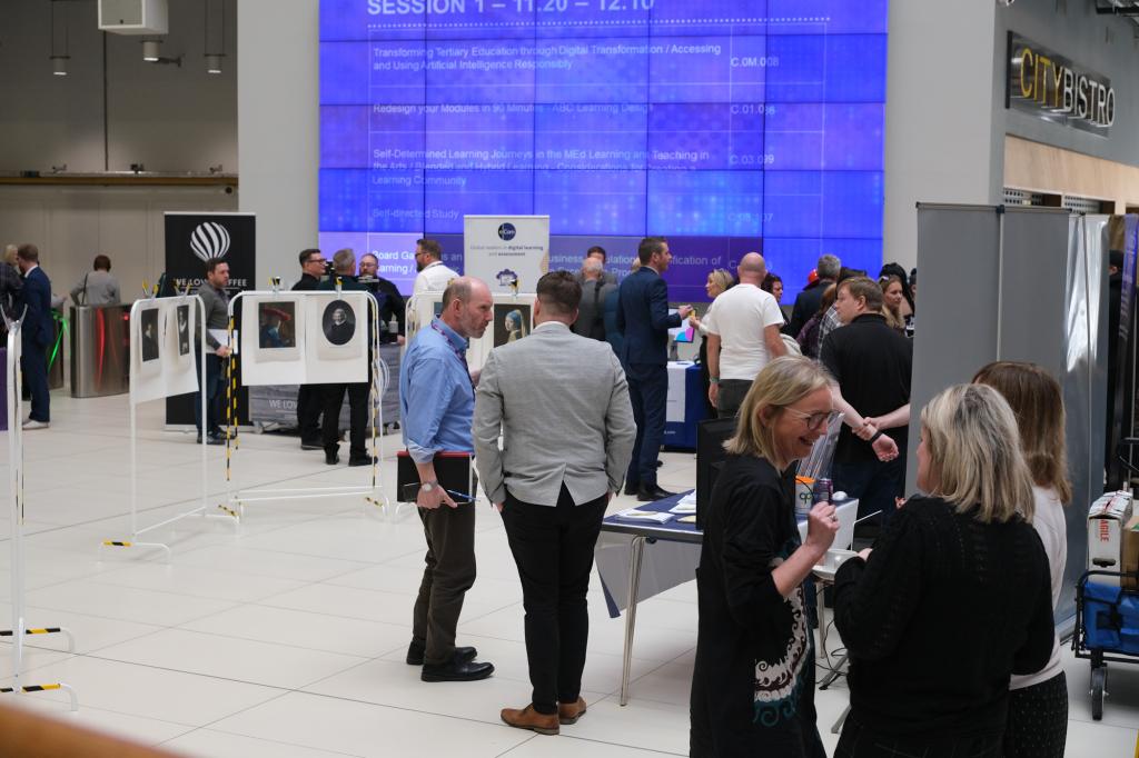 Staff in the atrium at City campus talking to exhibitors