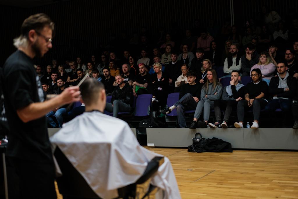 Barber.josh.o.p trainers demonstrating cutting techniques on stage at City campus