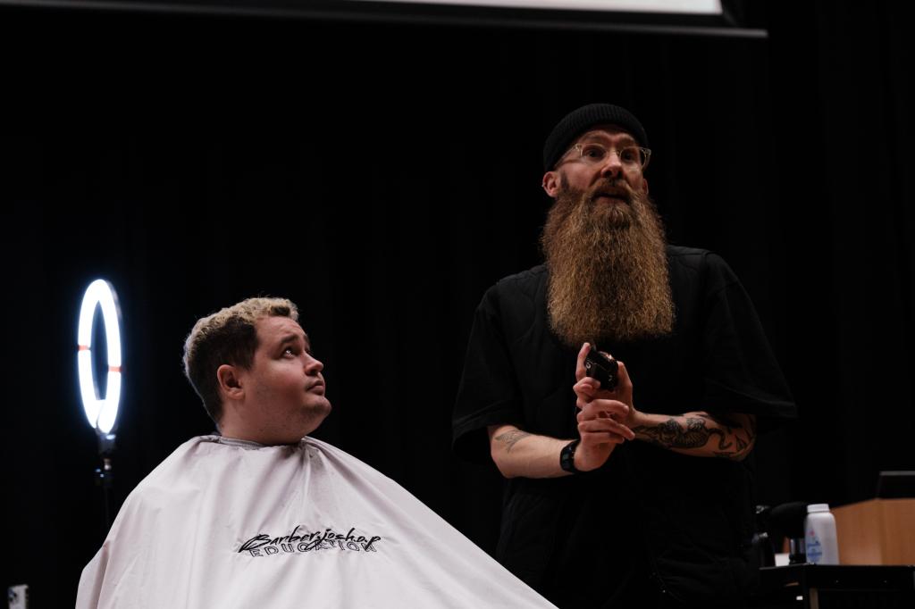 Barber.josh.o.p trainers demonstrating cutting techniques on stage at City campus