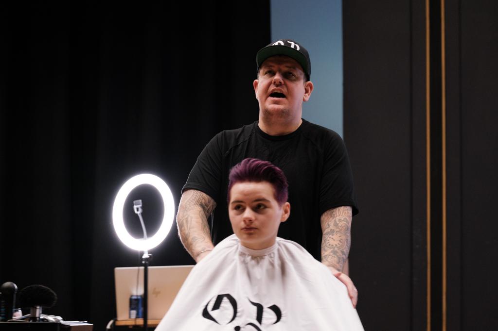 Barber.josh.o.p trainers demonstrating cutting techniques on stage at City campus