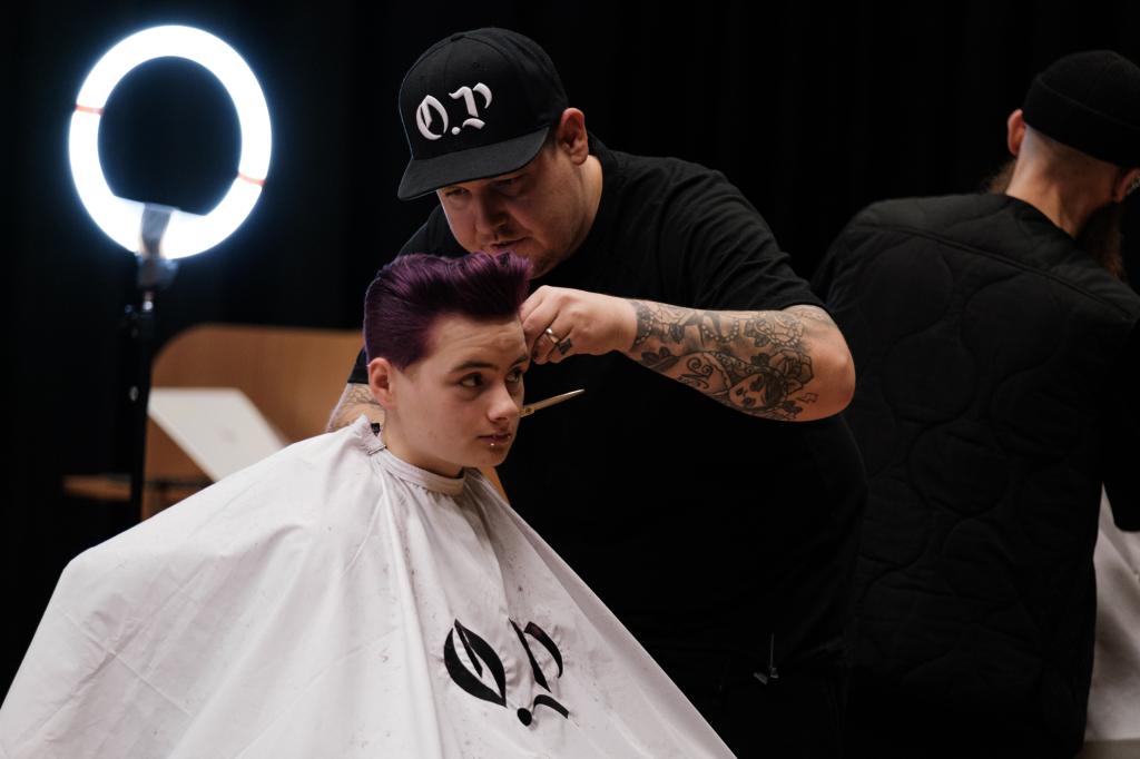 Barber.josh.o.p trainers demonstrating cutting techniques on stage at City campus