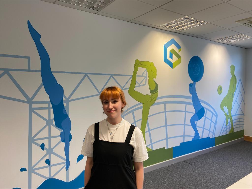 Falyne standing in front of her completed mural.