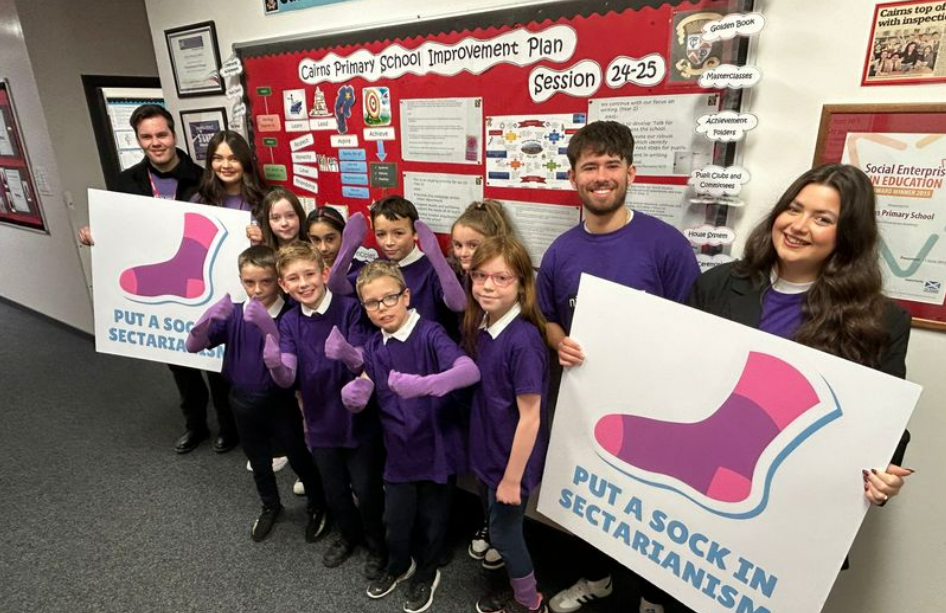 Ben McGovern, Ellie Harkins, Nalin Botterill and Philippa Lynas stand with primary school children (Image: Nil by Mouth)