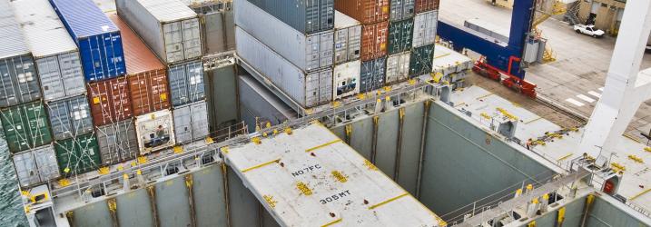 Stacks of shipping containers in a harbour storage area.