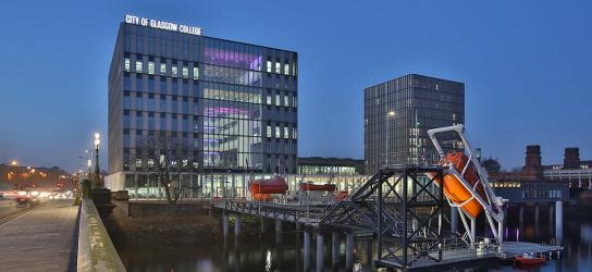 Riverside campus buildings inthe background with the marine jetty and lifeboats at the front. Taken at dusk.