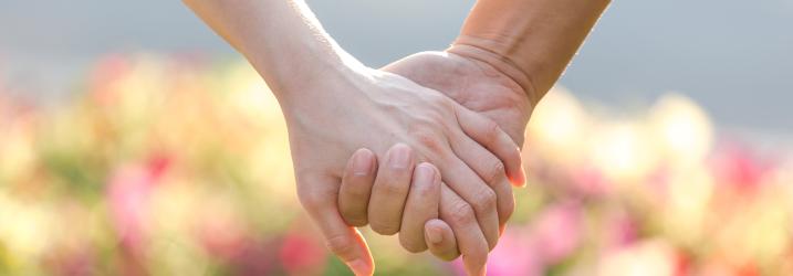 A close up of a couple holding hands