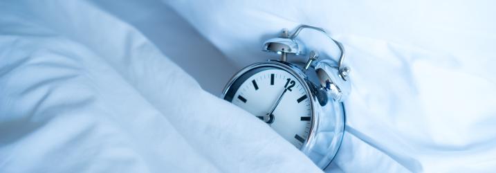 An alarm clock resting on a pillow